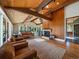 Open-concept living and dining area with vaulted wood ceilings, hardwood floors, and fireplace at 31756 Buffalo Park Rd, Evergreen, CO 80439