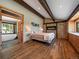 This main bedroom features a stone fireplace, wood beams, and a luxurious bathroom with a soaking tub at 31756 Buffalo Park Rd, Evergreen, CO 80439