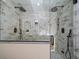 A luxurious shower with double shower heads, marble tiling, and glass doors in this modern bathroom at 31756 Buffalo Park Rd, Evergreen, CO 80439