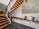 Inviting staircase with rustic wood treads and bench seating, complemented by a striking bridge art piece at 31756 Buffalo Park Rd, Evergreen, CO 80439