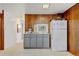 Basement kitchenette features gray cabinets, a white refrigerator, and wood paneling at 345 Central Ave, Brighton, CO 80601