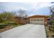 Front exterior view of the home with a large driveway and a two-car garage at 345 Central Ave, Brighton, CO 80601