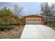 Front exterior view of the home with a large driveway and a two-car garage and garden at 345 Central Ave, Brighton, CO 80601