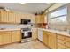 Cozy kitchen features light wood cabinets, tile backsplash, and stainless steel appliances at 345 Central Ave, Brighton, CO 80601