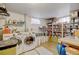 Organized laundry room with washer, dryer, storage shelving, cleaning supplies, and natural light from the window at 345 Central Ave, Brighton, CO 80601