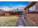 A well-kept backyard highlighting a covered patio with outdoor seating and a stone pathway at 7131 Raritan St, Denver, CO 80221