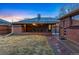 View of the backyard featuring a covered patio with an outdoor dining set and a lush lawn at 7131 Raritan St, Denver, CO 80221