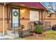 Close-up of a charming front porch with decorative ironwork and a welcoming entrance at 7131 Raritan St, Denver, CO 80221