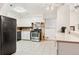 Well-lit kitchen with stainless steel appliances, tile flooring, and white cabinetry at 7131 Raritan St, Denver, CO 80221