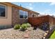 Landscaped backyard featuring a stone garden with flowers, shrubs, and a wood fence at 16141 W 64Th Way, Arvada, CO 80007