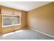 Tan bedroom featuring a large window with bright sunlight and neutral carpeting at 16141 W 64Th Way, Arvada, CO 80007