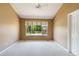 Spacious carpeted bedroom featuring a ceiling fan and a large window overlooking the front yard at 16141 W 64Th Way, Arvada, CO 80007
