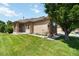 Well-manicured lawn and exterior view of this tan single-story home with brick accents at 16141 W 64Th Way, Arvada, CO 80007