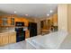 Well-lit kitchen featuring oak cabinetry, modern black appliances, and a peninsula with a double sink at 16141 W 64Th Way, Arvada, CO 80007