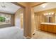 Ensuite bathroom with dual vanities, tiled floors, glass shower, and bedroom with large windows at 16141 W 64Th Way, Arvada, CO 80007