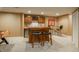 Basement bar area with wooden cabinets, seating, wine storage, and a stainless steel mini fridge at 19099 E Creekside Dr, Parker, CO 80134