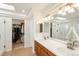 Bright bathroom boasting dual sinks, a large mirror, skylight, a glass-enclosed shower, and a walk-in closet at 19099 E Creekside Dr, Parker, CO 80134