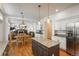 Open kitchen with granite counters, stainless appliances, island, and a view of the dining and living areas with fireplace at 19099 E Creekside Dr, Parker, CO 80134