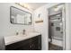 Bright bathroom features a modern vanity, a well-lit mirror, and a shower-tub combination at 2005 S Helena St # G, Aurora, CO 80013