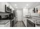 Modern kitchen features granite countertops, stainless steel appliances, and sleek white cabinets at 2005 S Helena St # G, Aurora, CO 80013