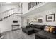 Bright living room with high ceilings, wood floors, open staircase, and view into kitchen at 2005 S Helena St # G, Aurora, CO 80013