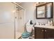 Bathroom featuring a shower with sliding doors, a toilet, and a vanity with dark wood cabinets at 17675 E Girard Ave, Aurora, CO 80013