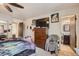 Bedroom featuring an ensuite bathroom, neutral walls, a TV, and wood furniture at 17675 E Girard Ave, Aurora, CO 80013