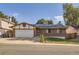 Cozy brick home featuring solar panels, an attached garage, and a well-maintained front yard at 17675 E Girard Ave, Aurora, CO 80013