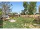 Large backyard with wooden fence, garden beds, fire pit area, and grassy space for outdoor activities at 7101 E 66Th Ave, Commerce City, CO 80022
