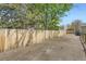 Backyard showing a gravel area adjacent to a tall, wood fence, leading to a gate and a glimpse of the house at 7101 E 66Th Ave, Commerce City, CO 80022
