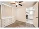Bedroom boasts neutral carpeting and ceiling fan; an open doorway looks onto the kitchen at 7101 E 66Th Ave, Commerce City, CO 80022