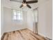 Bright bedroom with modern ceiling fan, light wood floors, and sheer window coverings at 7101 E 66Th Ave, Commerce City, CO 80022