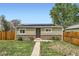 Inviting single-story home with well-manicured lawn, solar panels, and a cozy front entrance at 7101 E 66Th Ave, Commerce City, CO 80022
