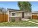 Charming single-story home with solar panels, stone accents, and well-maintained front yard at 7101 E 66Th Ave, Commerce City, CO 80022