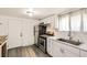 Modern kitchen features stainless steel appliances, white cabinetry, and updated fixtures at 7101 E 66Th Ave, Commerce City, CO 80022