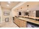 Basement wet bar featuring granite counters, wood cabinetry, pendant lighting, and stainless steel undercounter refrigerator at 6790 W Crestline Ave, Littleton, CO 80123