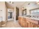 Bathroom featuring double sinks, a walk-in shower, and views to the bedroom at 6790 W Crestline Ave, Littleton, CO 80123