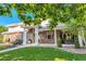 Gorgeous brick home with elegant columns, a well-manicured lawn, and lush landscaping at 6790 W Crestline Ave, Littleton, CO 80123