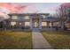 Stately brick and stucco home with a covered entrance and well-maintained landscaping at dusk at 6790 W Crestline Ave, Littleton, CO 80123