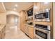 Modern kitchen with stainless steel appliances, granite countertops, and a built-in bar area with a television at 6790 W Crestline Ave, Littleton, CO 80123