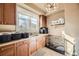Functional laundry room with ample counter space, storage cabinets, sink, and dog kennel at 6790 W Crestline Ave, Littleton, CO 80123