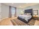Bedroom featuring a large bed, wood floors, soft blue walls, and a window with curtains at 6790 W Crestline Ave, Littleton, CO 80123