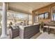 Covered patio with brick columns, wicker furniture, and a mounted television, perfect for outdoor entertaining at 6790 W Crestline Ave, Littleton, CO 80123