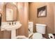 Charming powder room features a pedestal sink, framed mirror, and neutral color scheme at 6790 W Crestline Ave, Littleton, CO 80123
