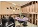 Wine room with custom wood racks, ambient lighting, and a table with seating at 6790 W Crestline Ave, Littleton, CO 80123