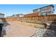 Backyard area featuring stone patio, small garden beds, rock landscaping, and a wooden fence at 9248 Salida St, Commerce City, CO 80022