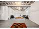 Unfinished basement with white wrapped walls, exposed ceiling, and area rugs defining seating areas at 9248 Salida St, Commerce City, CO 80022