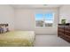 A neutral bedroom features a bed, large window with a view, and wood dresser at 9248 Salida St, Commerce City, CO 80022
