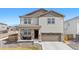 Two-story home featuring stone accents, covered porch, and a two-car garage at 9248 Salida St, Commerce City, CO 80022