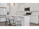 Bright kitchen features white cabinetry, stainless appliances, an island with seating, and modern finishes at 9248 Salida St, Commerce City, CO 80022